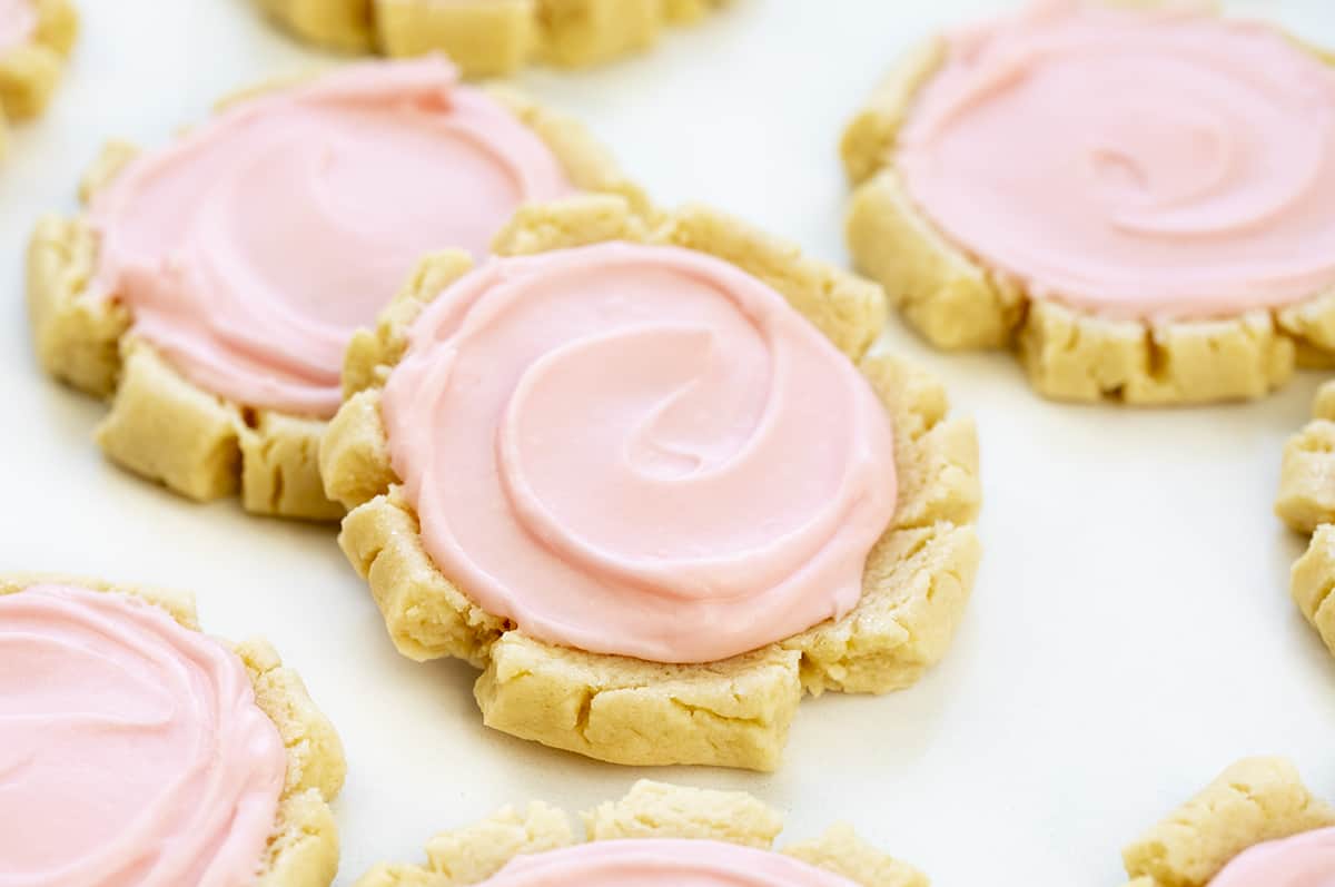 Copycat Swig Sugar Cookie on White Counter with Other Cookies. Dessert, Cookies, Cookie Recipes, Swig Copycat, Baking, Cookie Exchange, Frosted Cookies, iambaker cookie recipes, the best sugar cookies, sugar cookie, i am baker, iambaker
