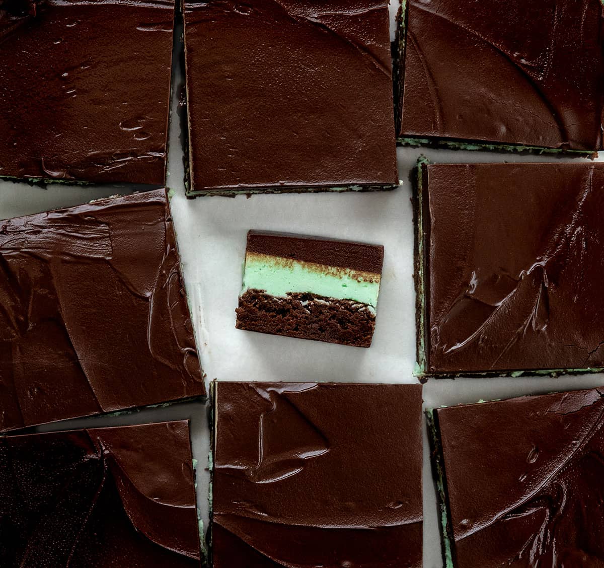Fudgy Chocolate Mint Brownies cut into squares and the center sqaure on its side.
