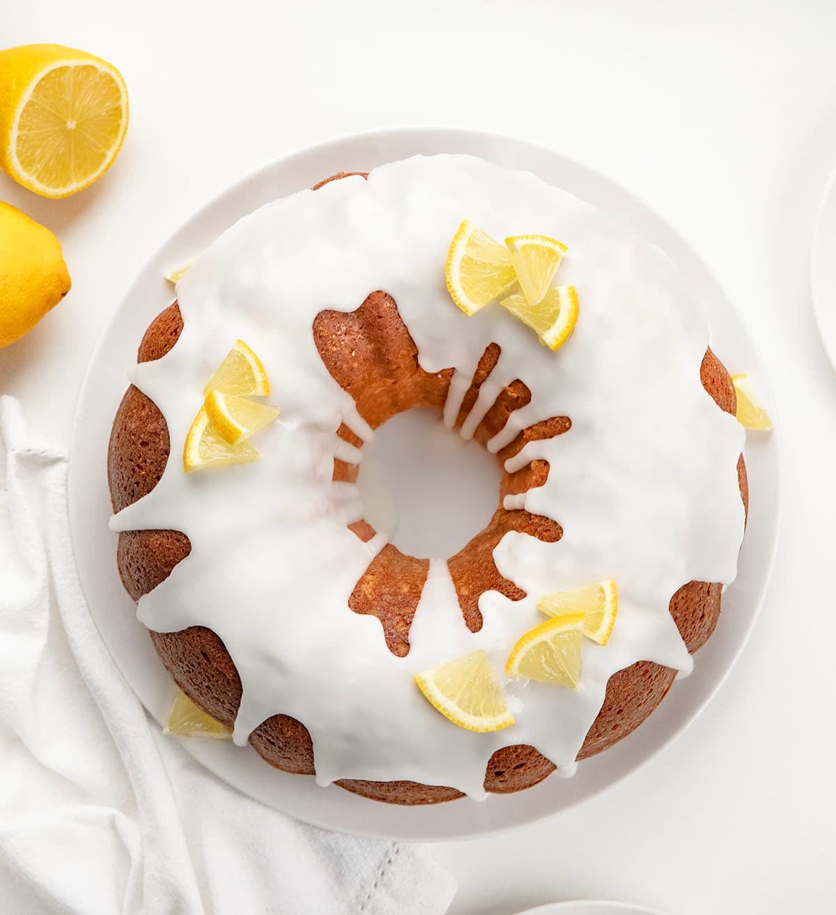 Lemon Pound Cake on a white platter on a white table from overhead.