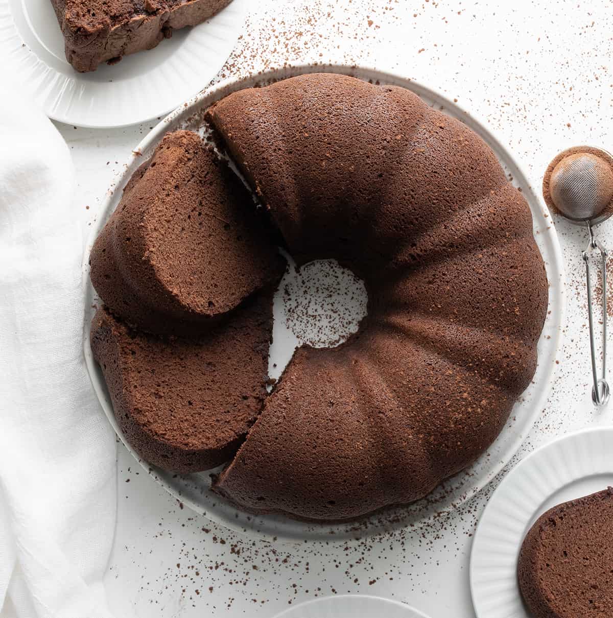 Chocolate Pound Cake on a White Cake Plate with Pieces Around From Overhead.