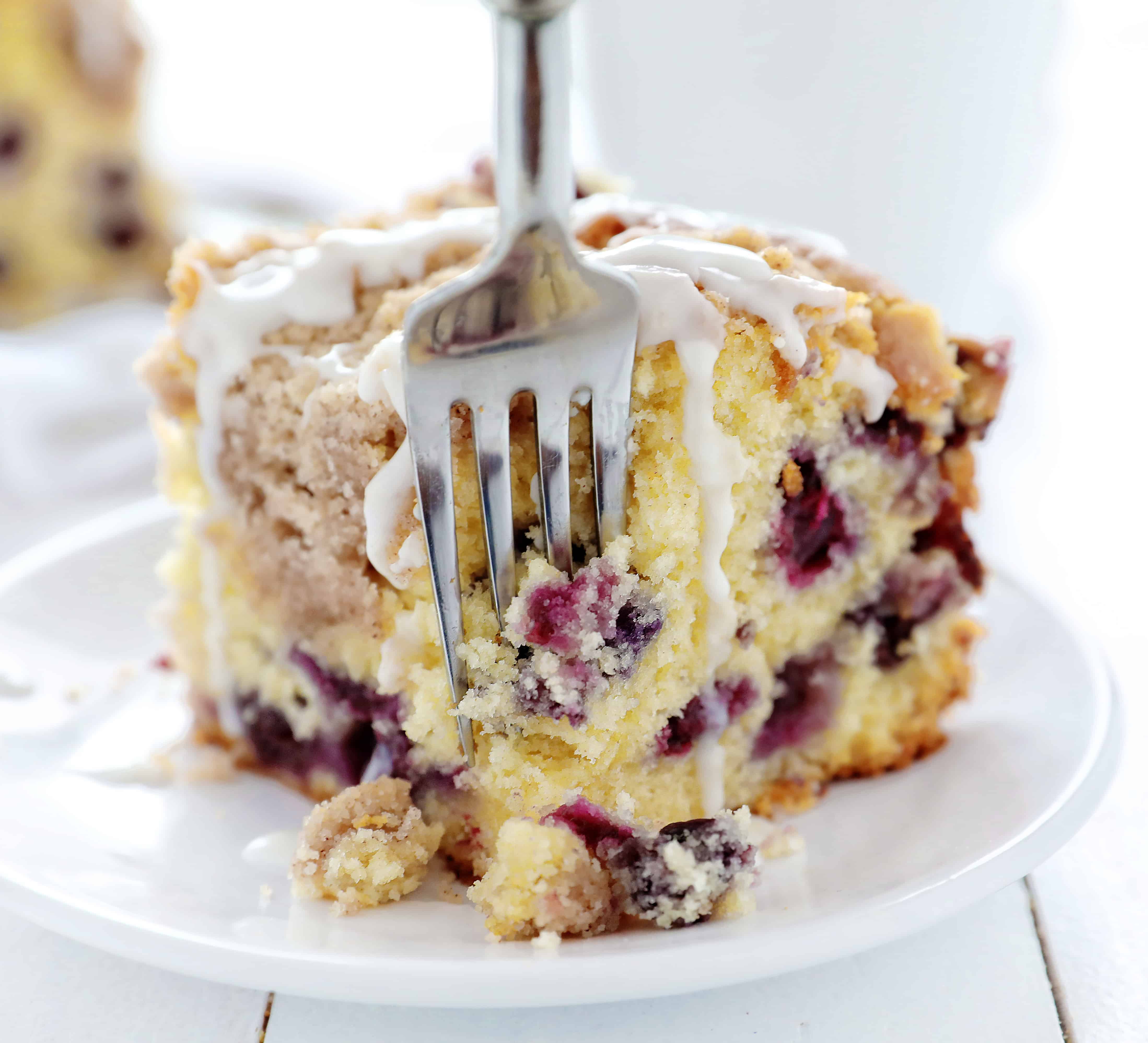 Blueberry Coffee Cake on White Plate with Fork Removing a Bite