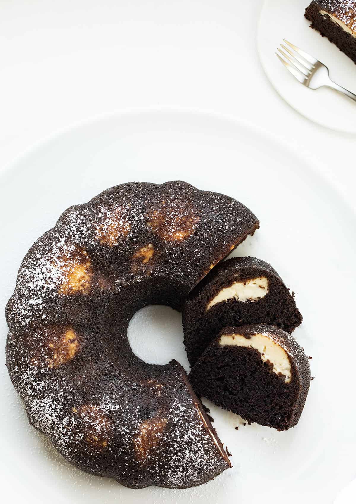 Chocolate Bundt with Cream Cheese Filling From Overhead with Cut Pieces Showing Inside. Dessert, Baking, Chocolate, Chocolate Dessert, Bundt Cake, Cake, Cake Recipes, Filled Bundt Cake, Nothing but Bundts Cake, Baking Recipes, i am baker, iambaker