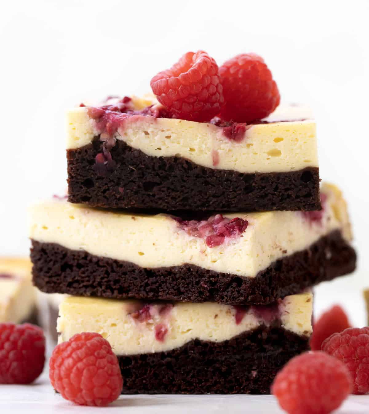 Stack of Raspberry Cheesecake Brownies on a white table.