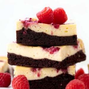Stack of Raspberry Cheesecake Brownies on a white table.