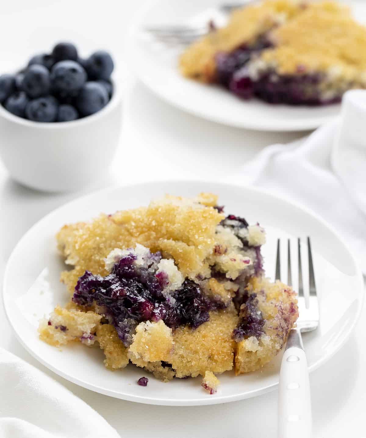 Piece of Blueberry Cobbler on a Plate with Another Plate in Background. Dessert, Cobbler, Blueberry Cobbler, Easy Summer Desserts, Summer Dessert, Blueberry Dessert, i am baker, iambaker.