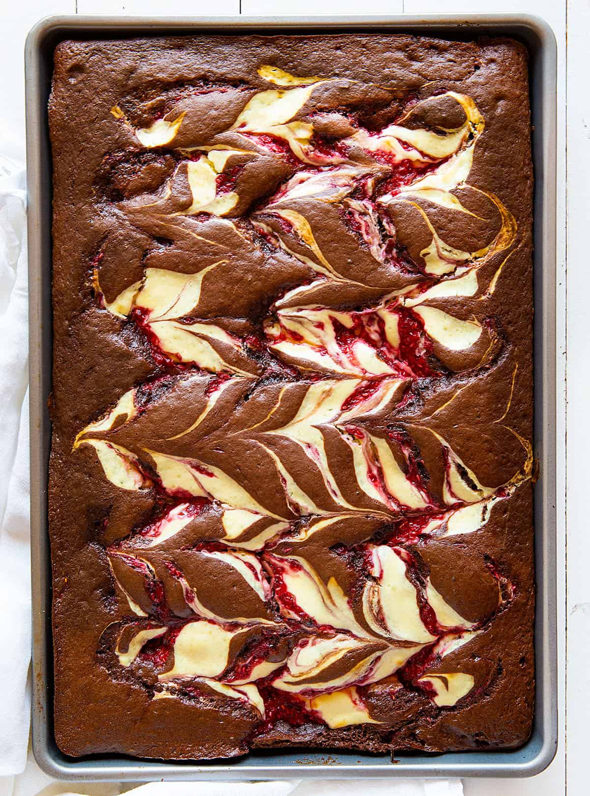 Raspberry Cheesecake Sheet cake on a white table from overhead.