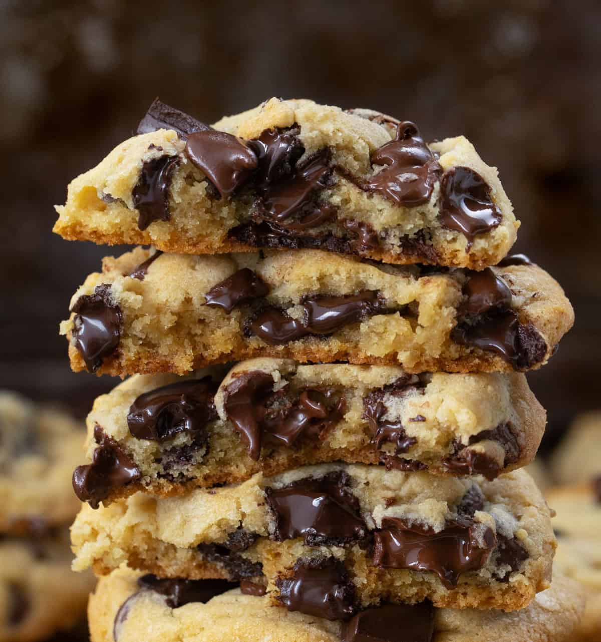 Close up of a stack of halved Chocolate Chip Cookies all with melted chocolate.