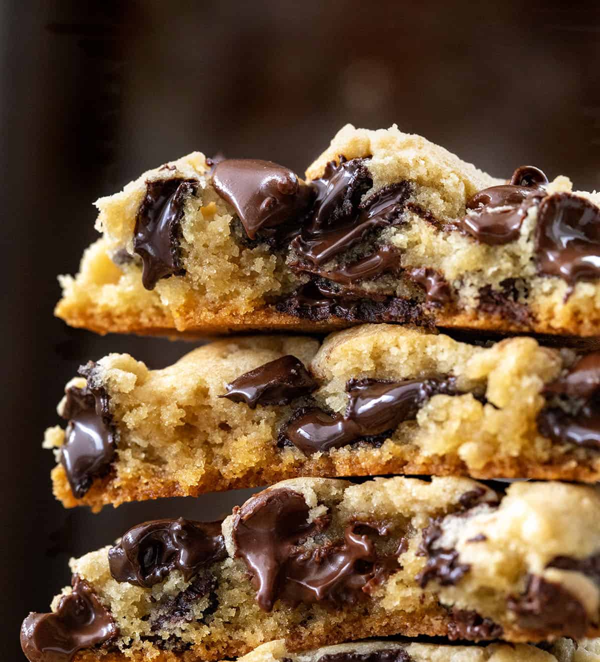 Very close up of Chocolate Chip Cookies that are broken in half showing the soft, melted chocolate inside the cookies.