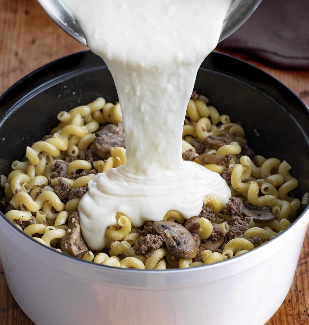 Adding Swiss Cheese Sauce to Mushroom Swiss Pasta. Dinner, Supper, Mushroom Swiss Macaroni and Cheese, Mushroom Swiss Noodles, Easy Dinner Idea, Hamburger, Ground Beef Dinner Ideas, Ground Beef Recipes, i am baker, iambaker