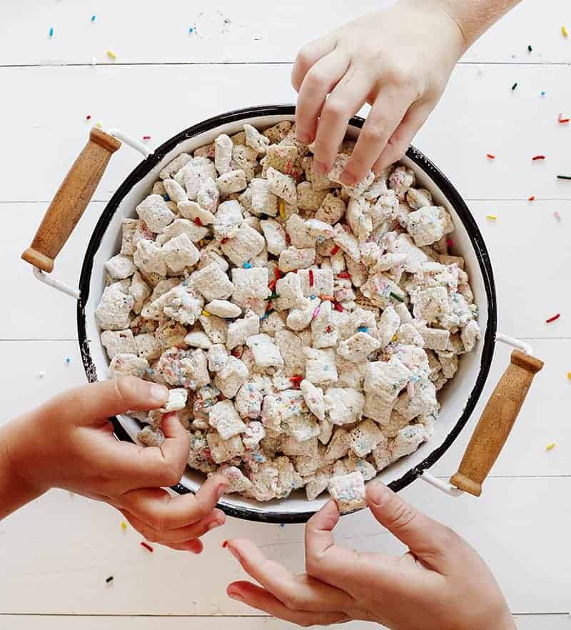 Childs hands Grabbing Birthday Cake Puppy Chow in a Bowl