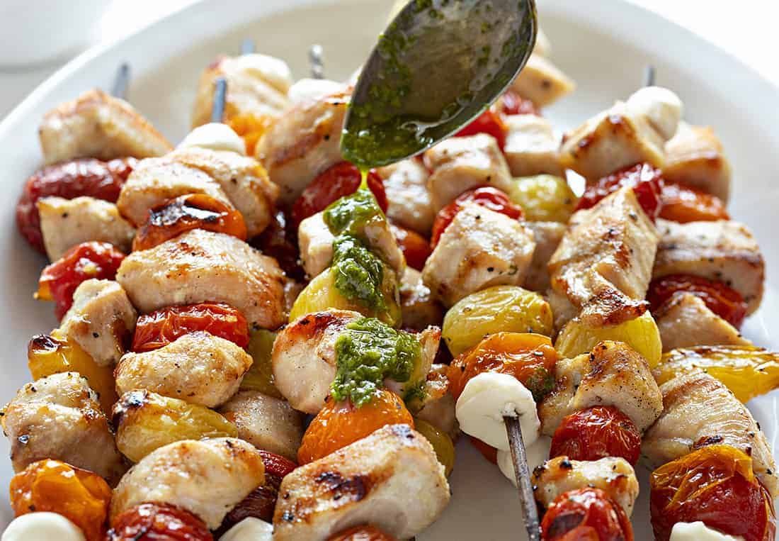 Chicken Caprese Skewers drizzled in lemon pesto.