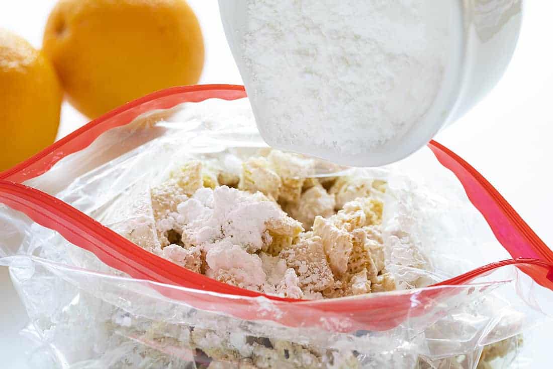 Adding Powdered Sugar to Orange Creamsicle Puppy Chow