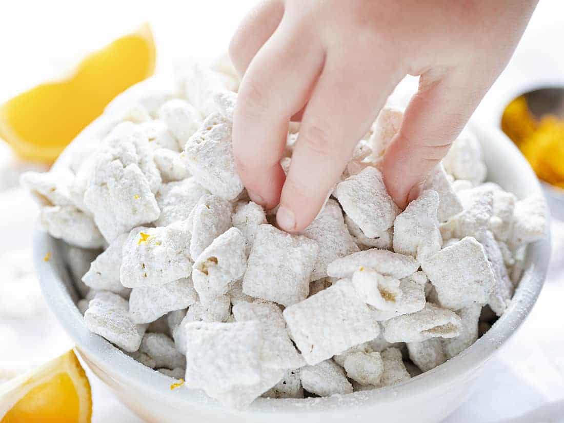 Child Taking Handful of Creamsicle Puppy Chow