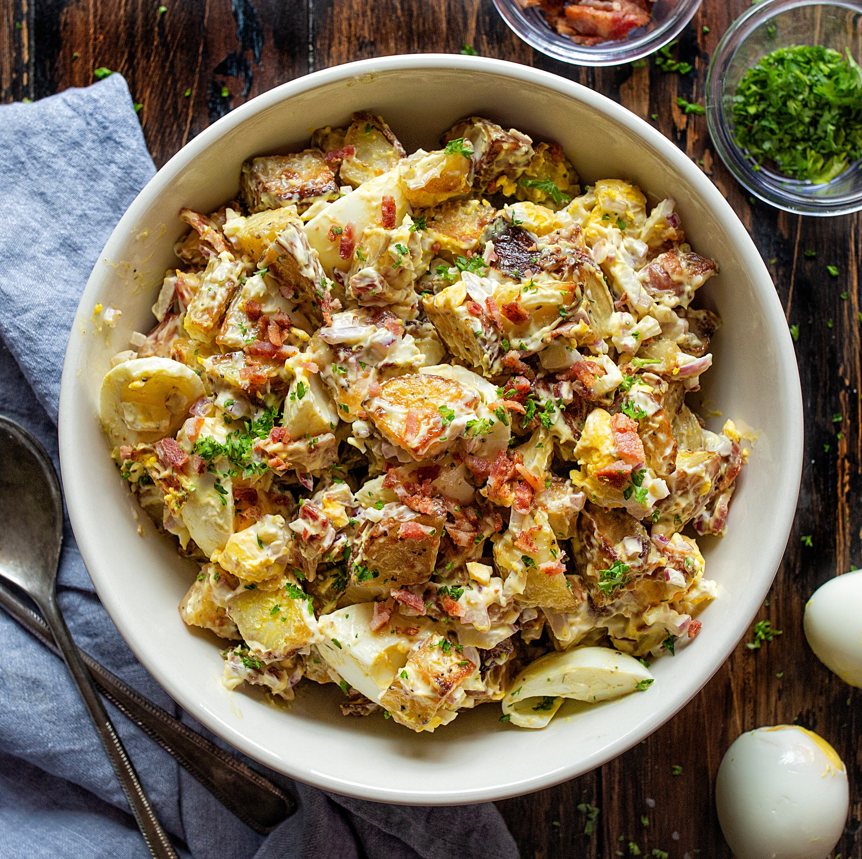 Perfect Roasted Potato Salad in a Bowl on a Wooden Cutting Board.