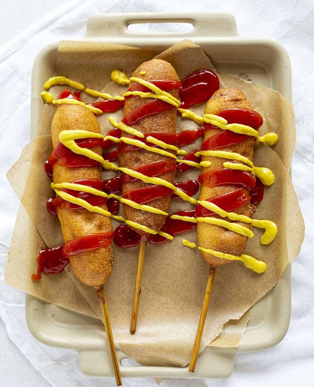 Three pronto pups drizzled in ketchup and mustard