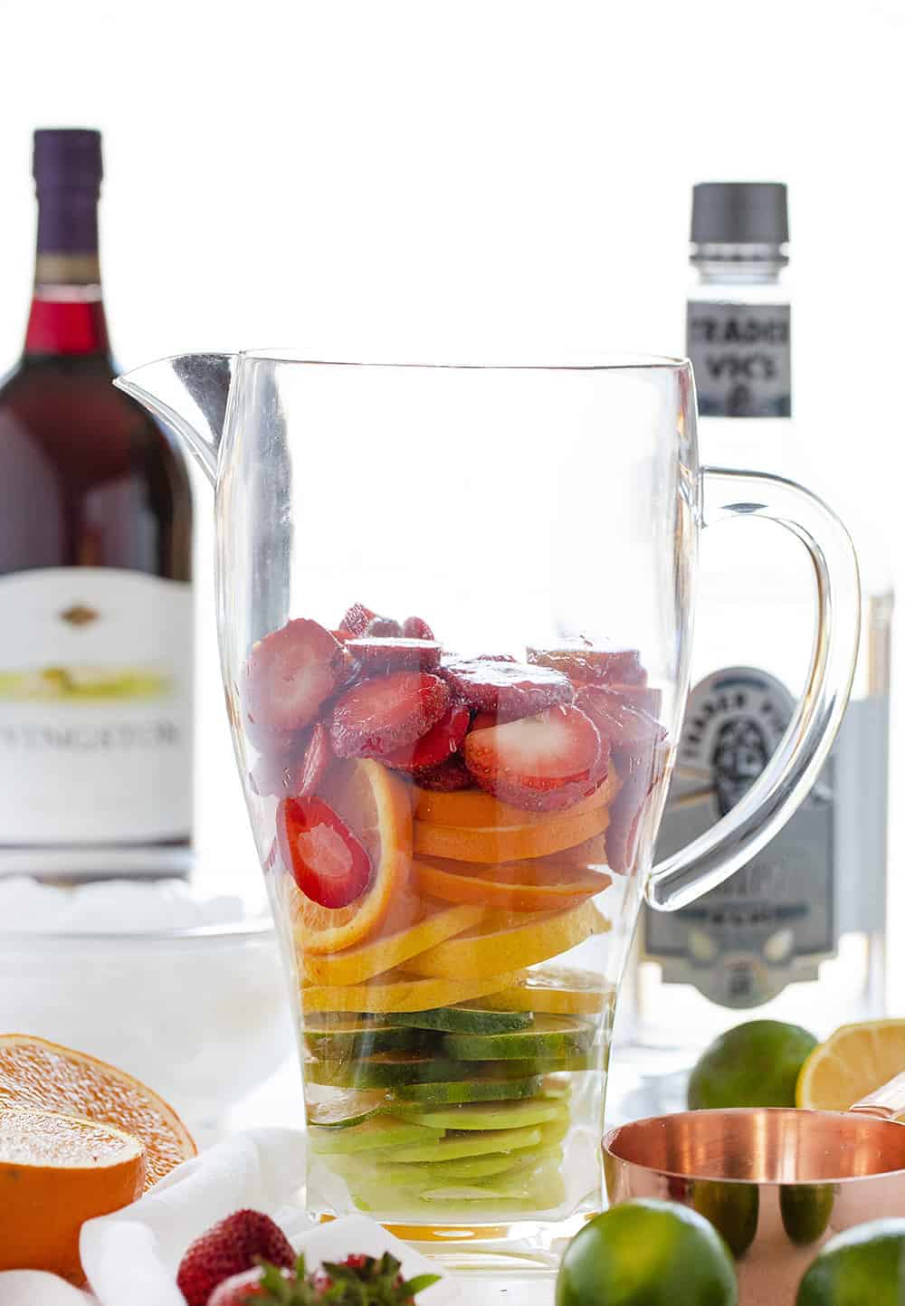 Piles of colorful fruit in a pitcher of Summer Sangria