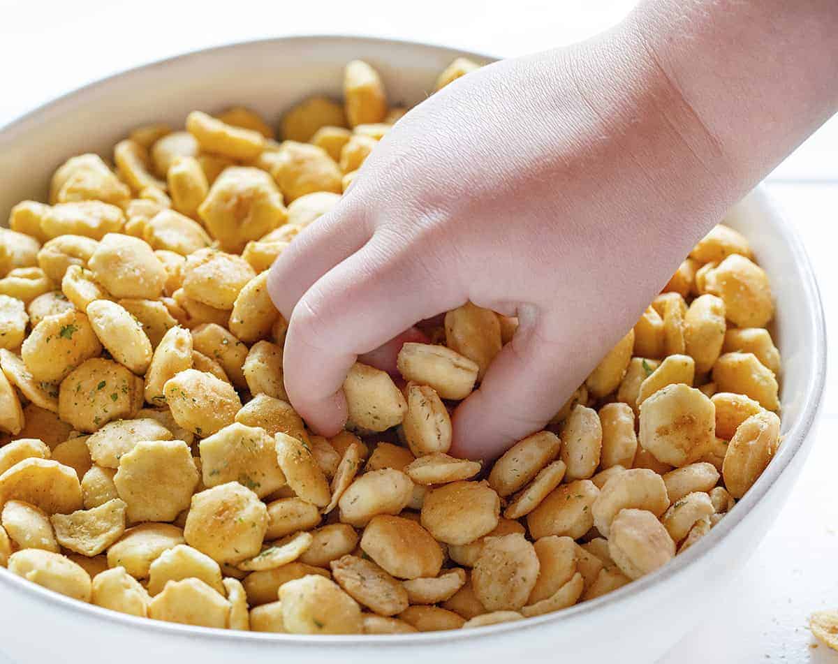 hand in bowl of seasoned oyster crackers