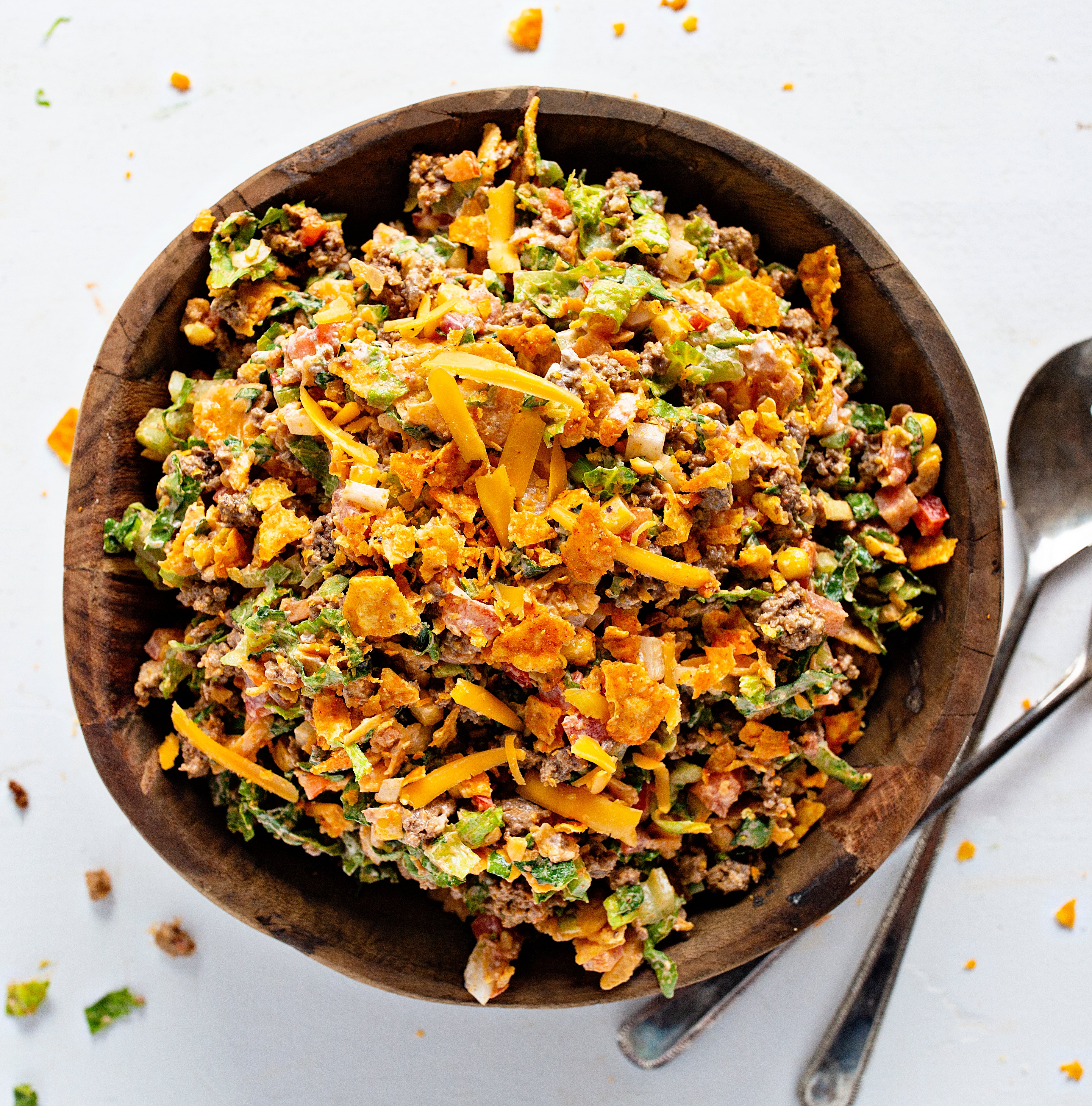 Taco Salad will make taco night a hit in your house again! taco, tacos, taco salad, taco fixings, dorito salad, dorito taco salad, salad, summer salad, summer salad recipes, taco recipes, taco salad recipes, dorito taco recipe, iambaker, i am baker, bbq recipes, cookout recipes, summer recipes, french dressing salad Taco Salad in a Wooden Bowl from Overhead.