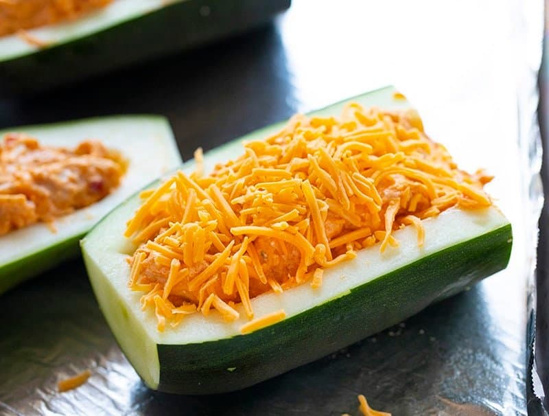 Stuffing buffalo chicken and cheese into an uncooked zucchini boat