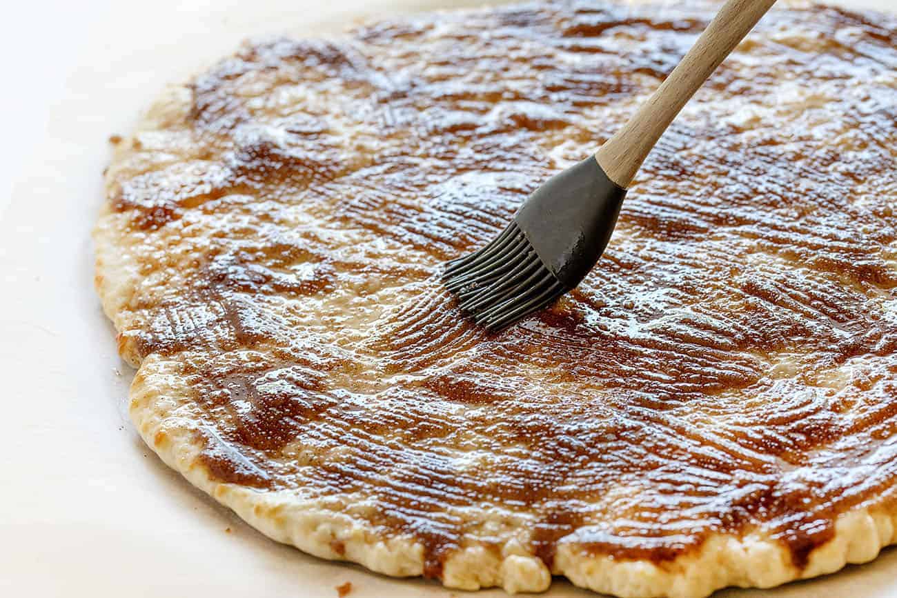 Spreading butter and cinnamon mixture over pizza dough for Cactus Bread