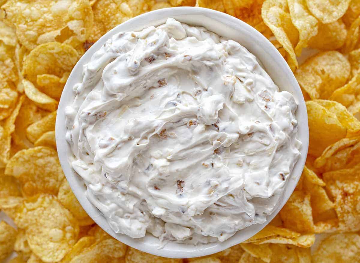 Bowl of Caramelized French Onion Dip with Potato Chips Around It.