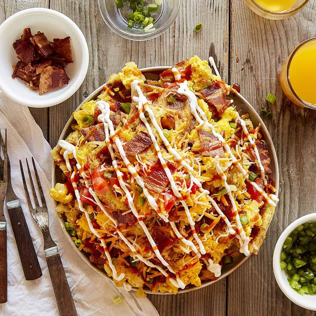 Adding sour cream and hot sauce to Loaded Hash Brown Breakfast Nachos