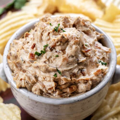Bowl of Caramelized French Onion Dip with Potato Chips Around It.