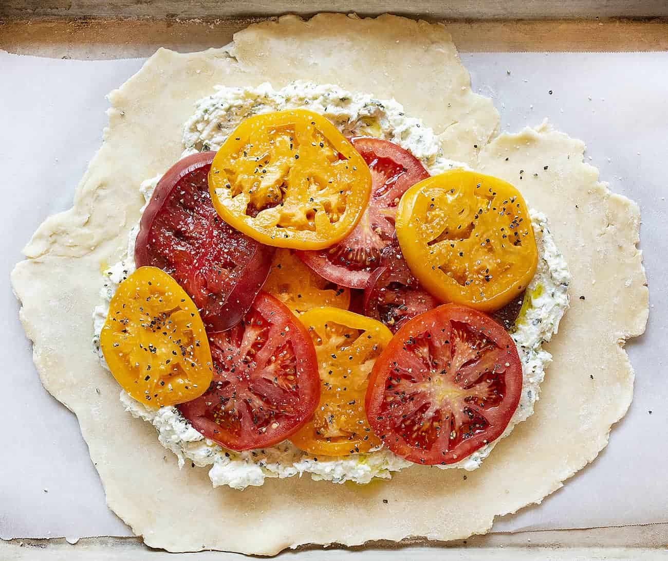 Raw Ingredients Piled on Dough for a Tomato Galette.