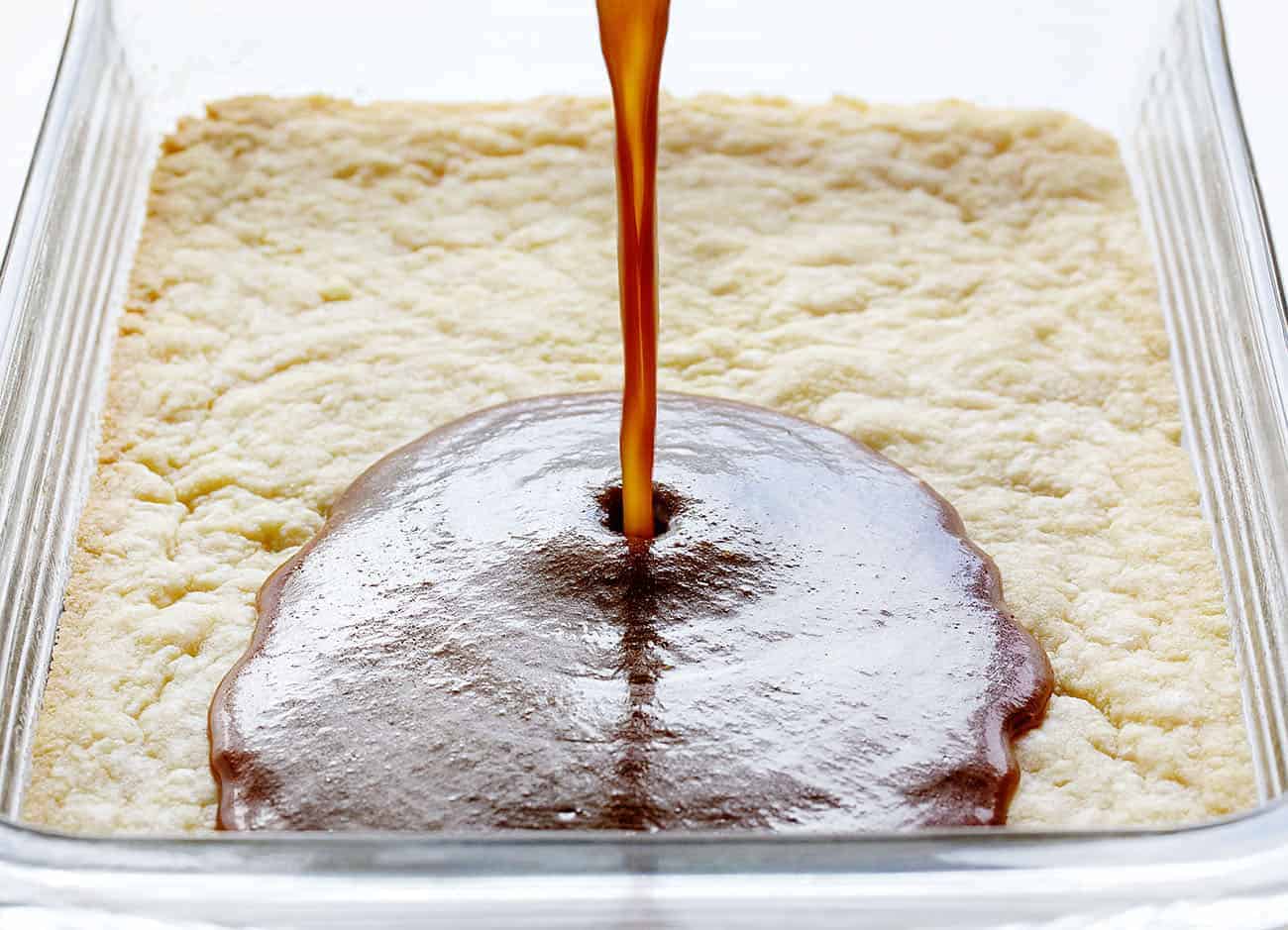 Pouring Homemade Pumpkin Caramel over the Butter Bars for Caramel Pumpkin Butter Bars