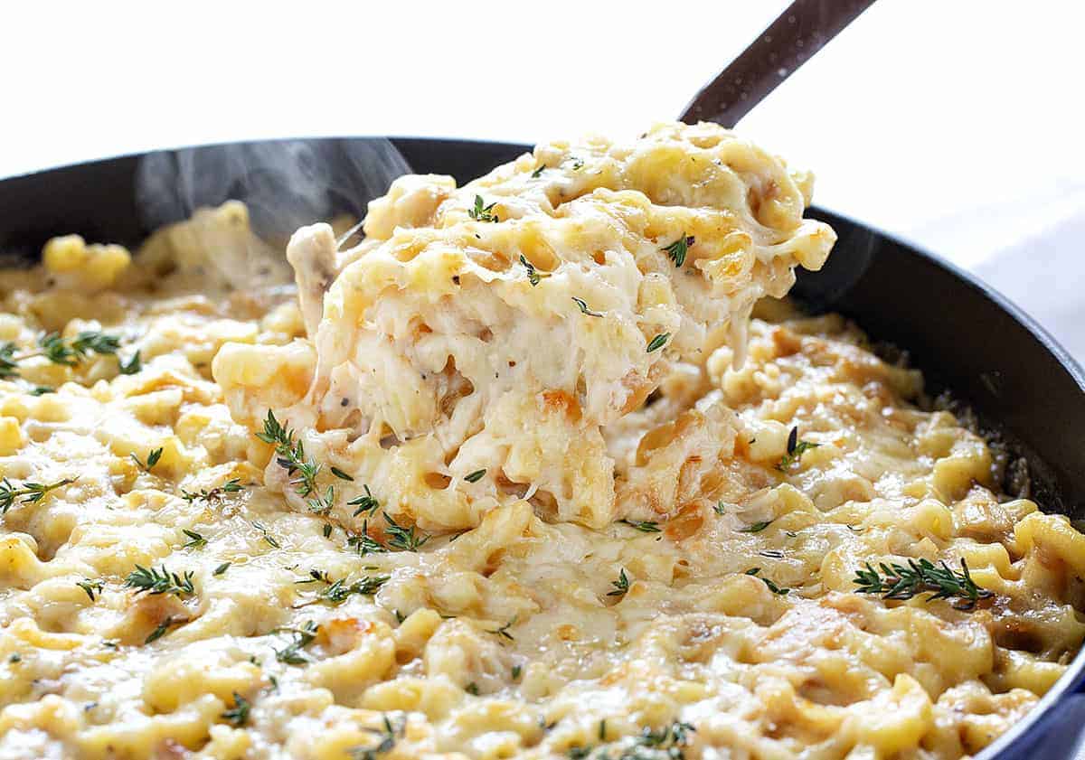 Taking a Scoop of French Onion Chicken Macaroni and Cheese Out of a Skillet