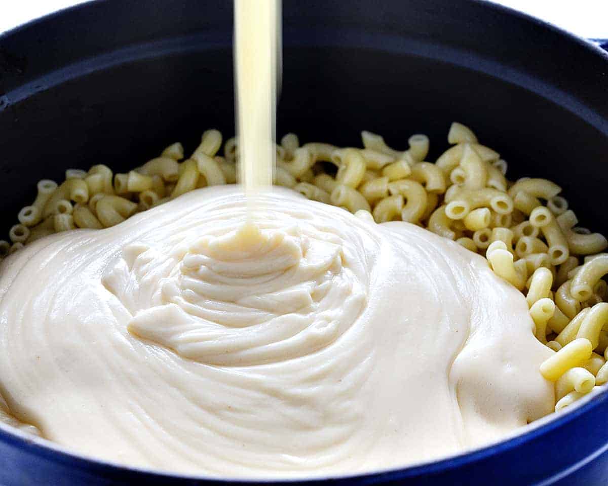 Pouring Cheese Sauce into Macaroni and Cheese