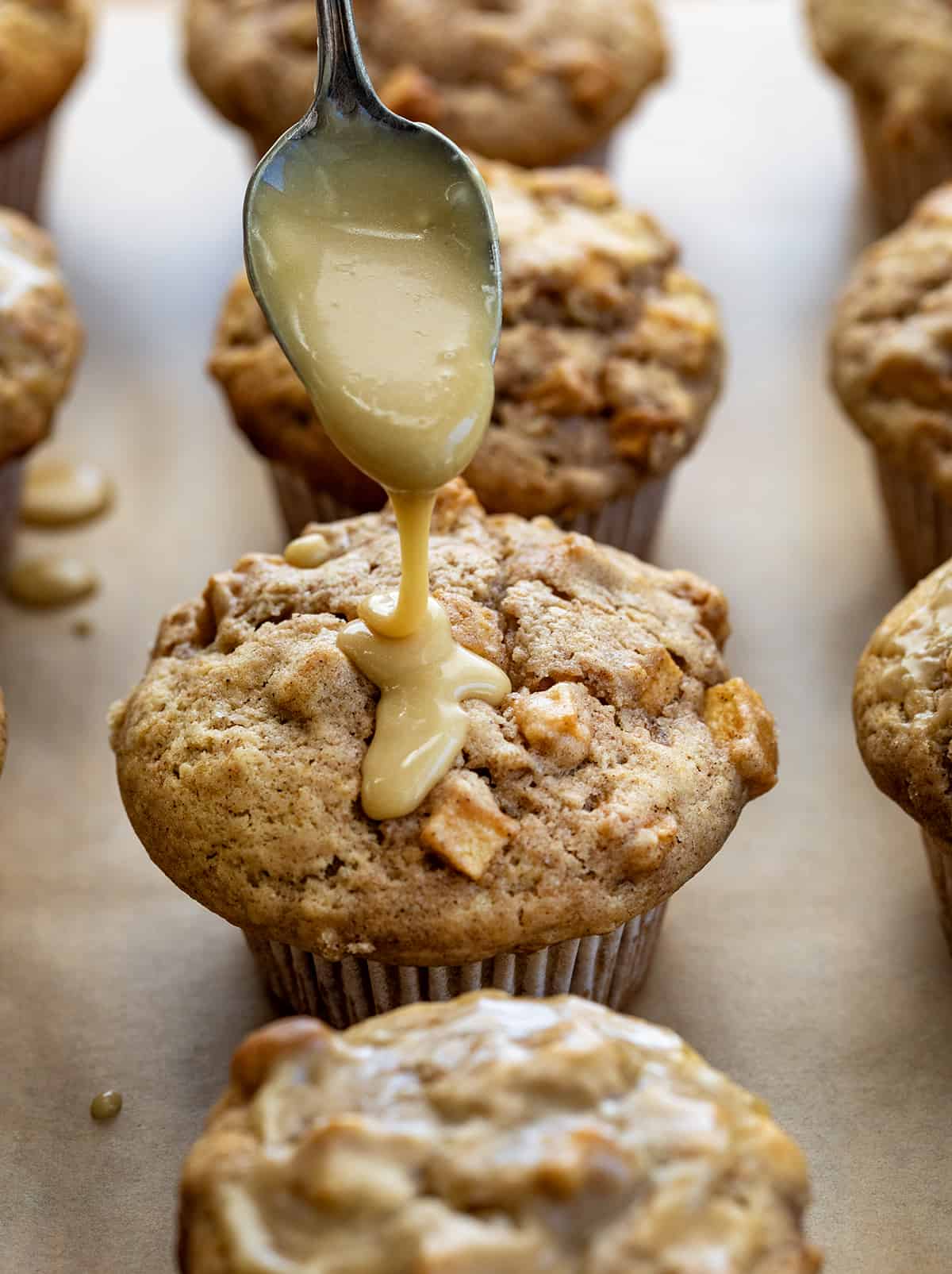 Drizzling Maple Glaze Over Freshly Baked Apple Muffins.