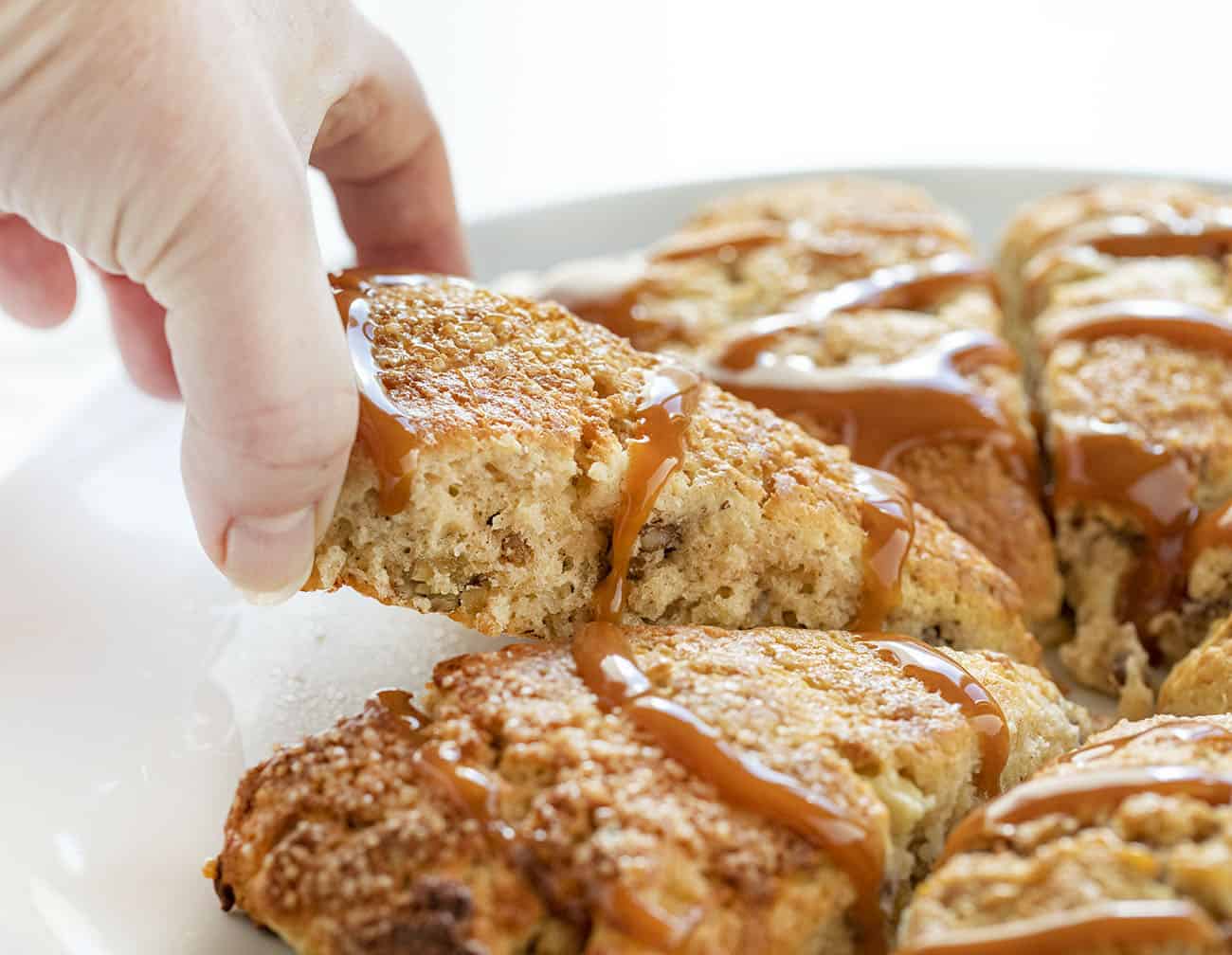 Hand Picking up a Caramel Apple Pecan Scone