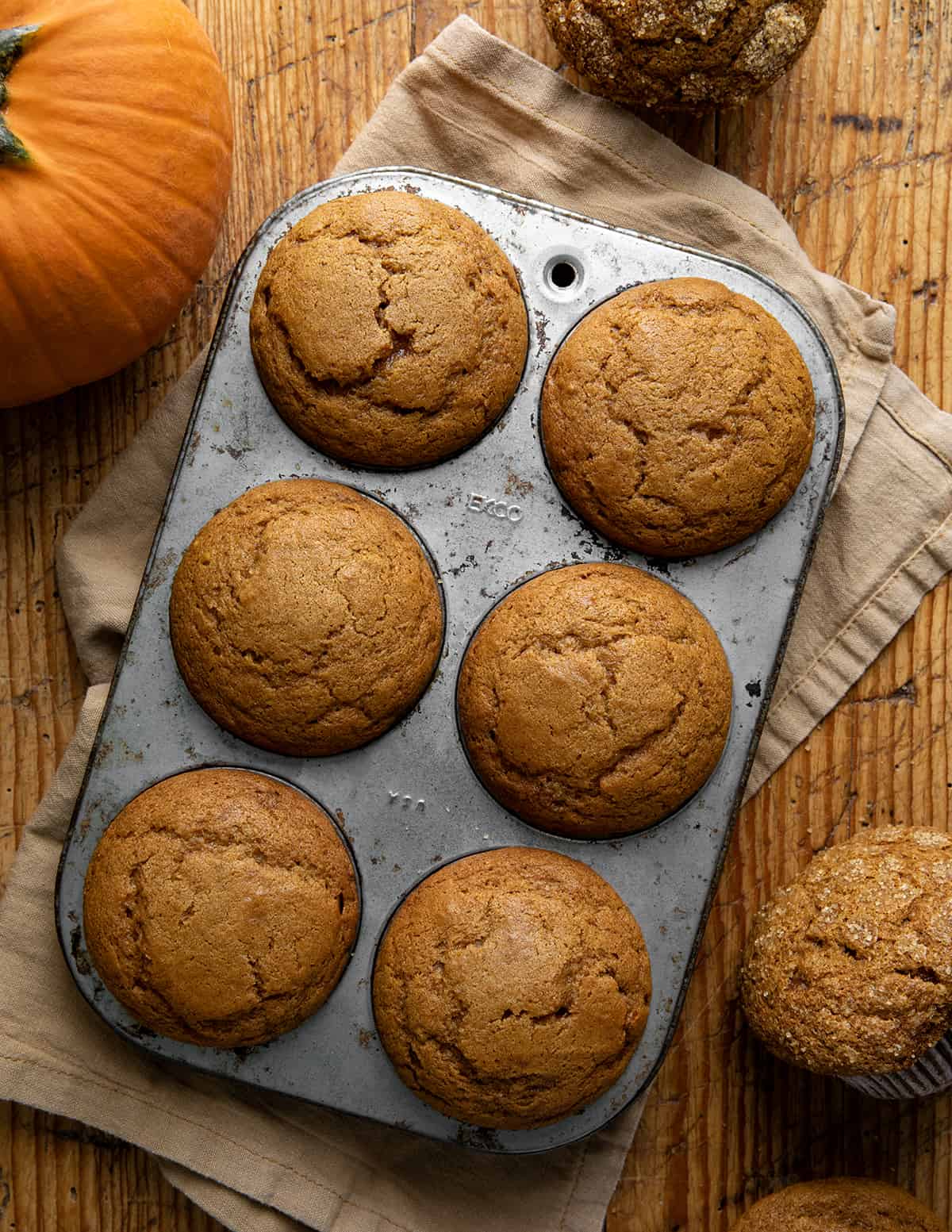Pumpkin Spice Muffins in a Muffin Pan on a Table from Overhead.