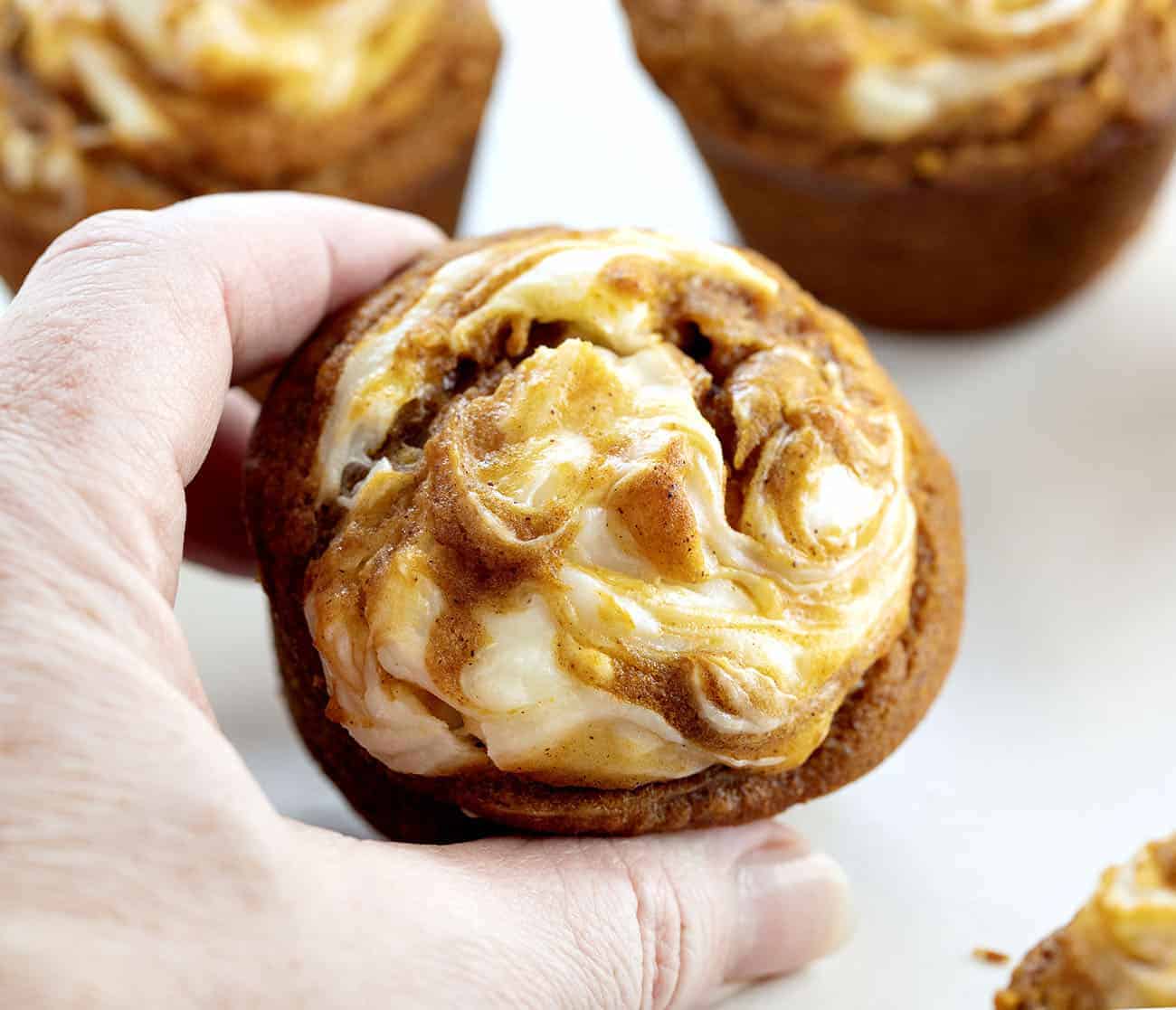 Hand Holding Pumpkin Cream Cheese Swirl Muffin