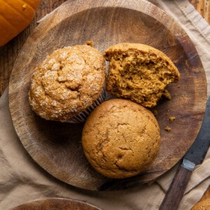 Pumpkin Spice Muffins on a wooden plate on a table from overhead.