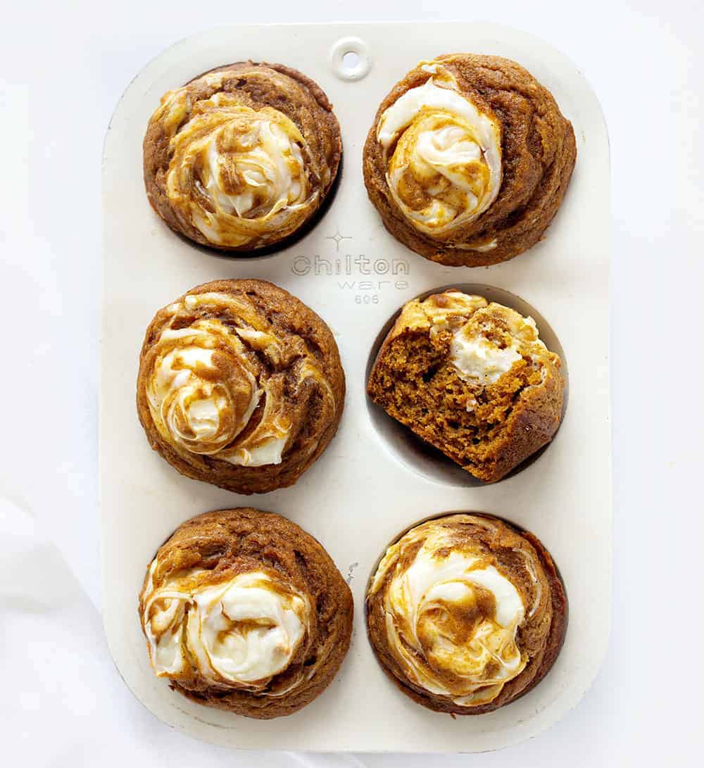 Overhead of Pumpkin Cream Cheese Swirl Muffins with One Halved