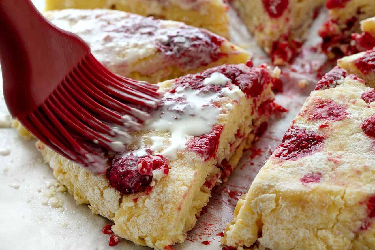 Brushing heavy Cream on White Chocolate Raspberry Scones