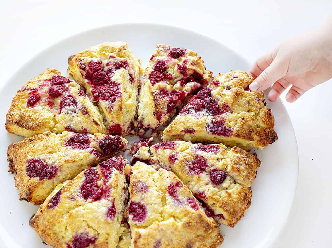 Child grabbing a piece of White Chocolate Raspberry Scones