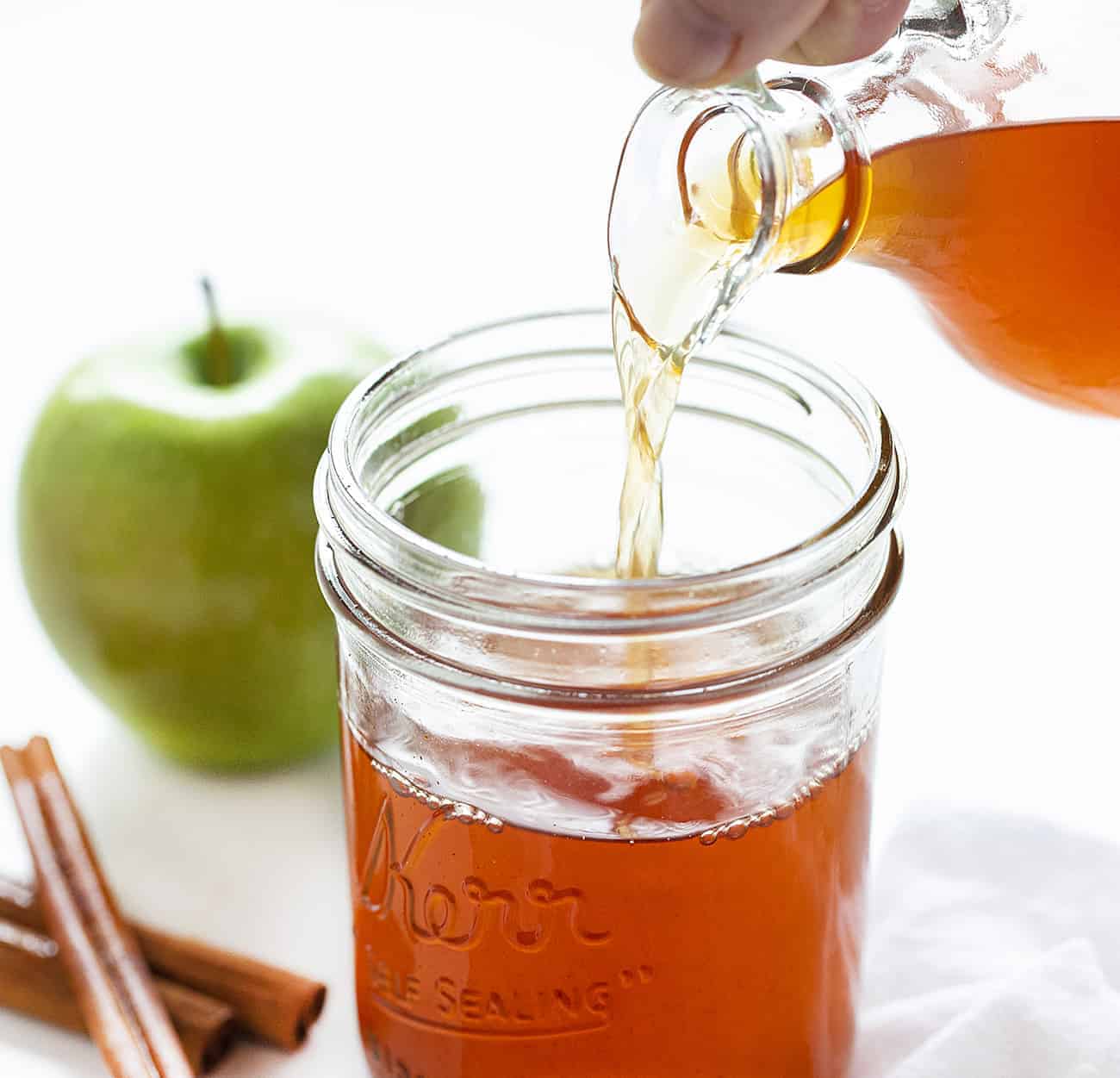 Pouring Cinnamon Apple Moonshine in Jar