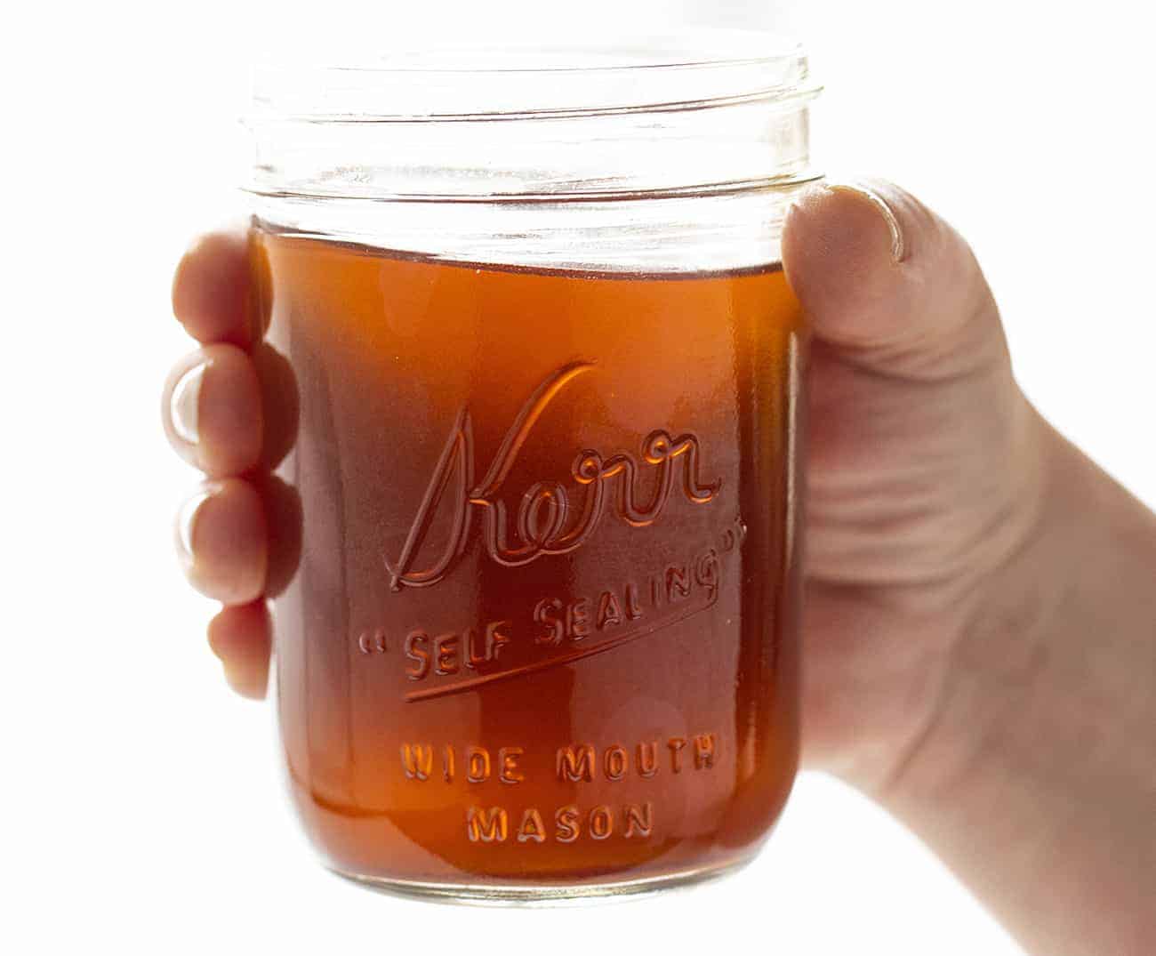 Hand holding jar of Cinnamon Apple Moonshine