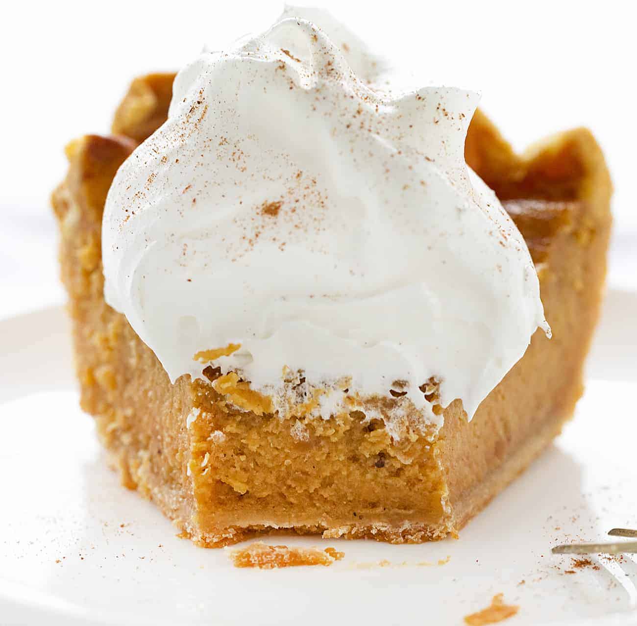 Bite Taken Out of Sweet Potato Pie with Whipped Cream on Top