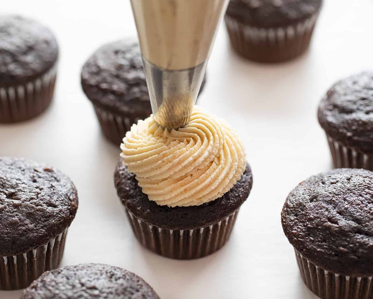 Piping Frosting onto Chocolate Cupcake