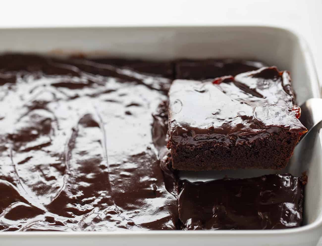 Cherry Brownies Being Taken Out of White Pan