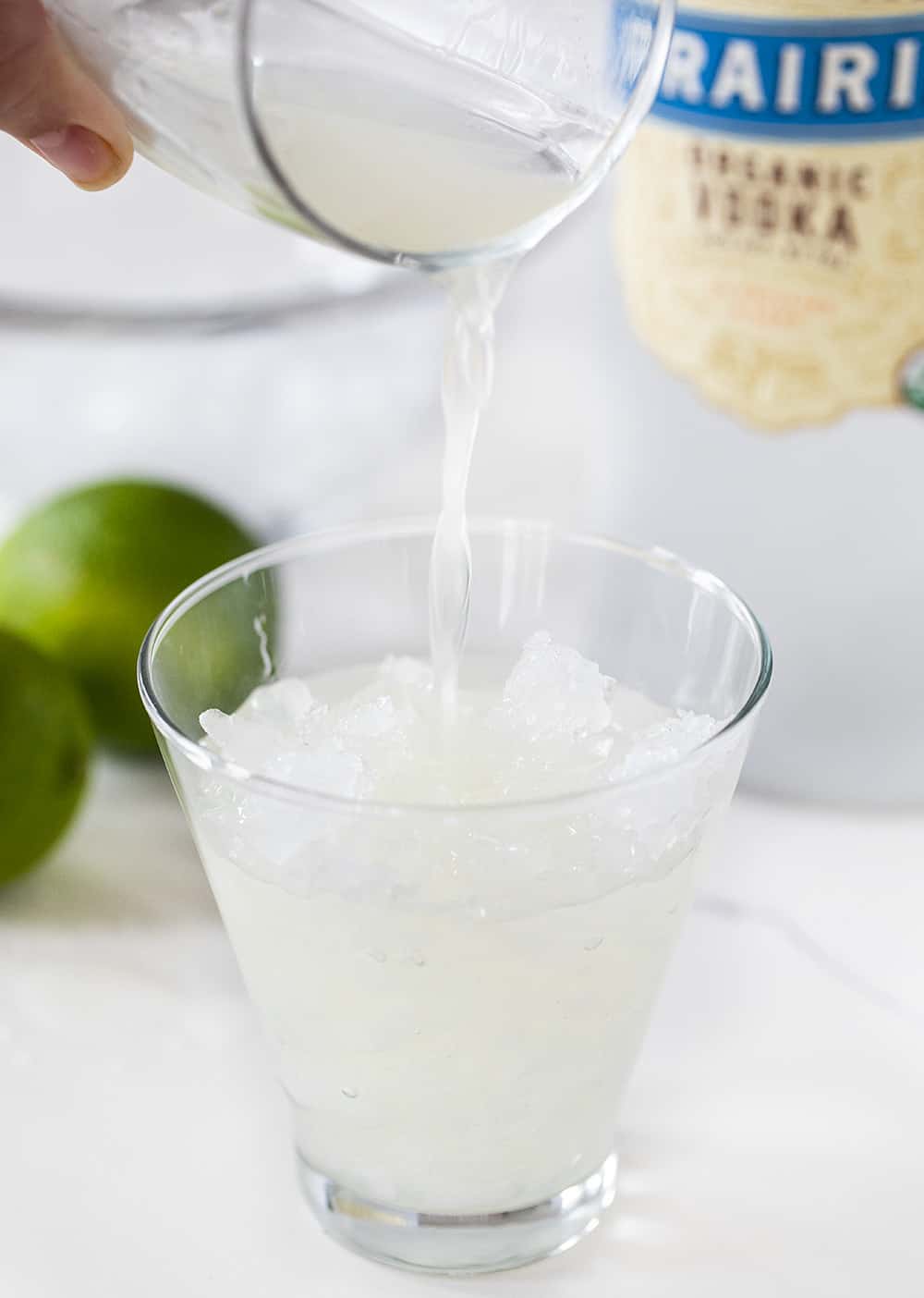 This Vodka Gimlet is made a bit sweeter by adding homemade simple syrup to the recipe. vodka gimlet, homemade simple syrup, simple syrup recipe, cocktail recipes, vodka drinks, i am baker, iambaker Pouring juice to Vodka Gimlet in cup of ice