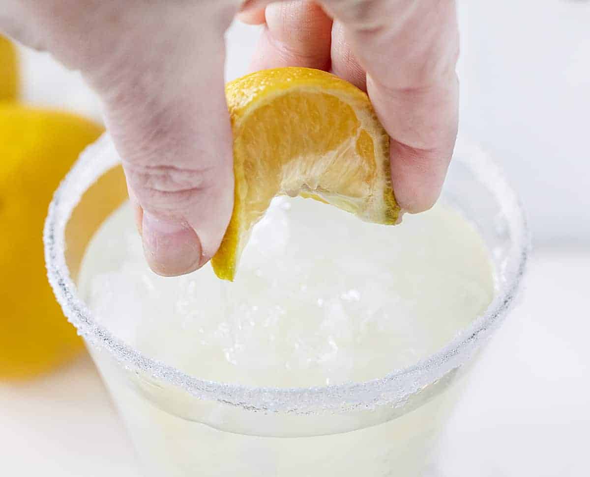 Squeezing Lemon into Lemon Drop Martini Glass with Sugar Rim