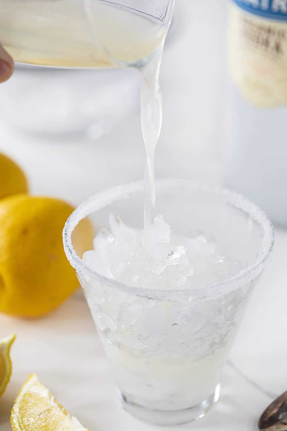 Pouring Lemon Mixture into Martini Glass to Make Lemon Drop Martini