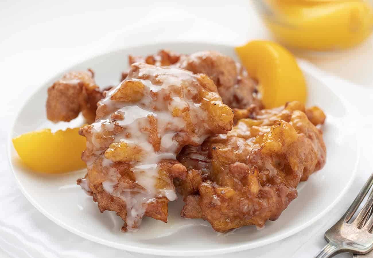 Homemade Peach Fritters on a White Plate with Peaches