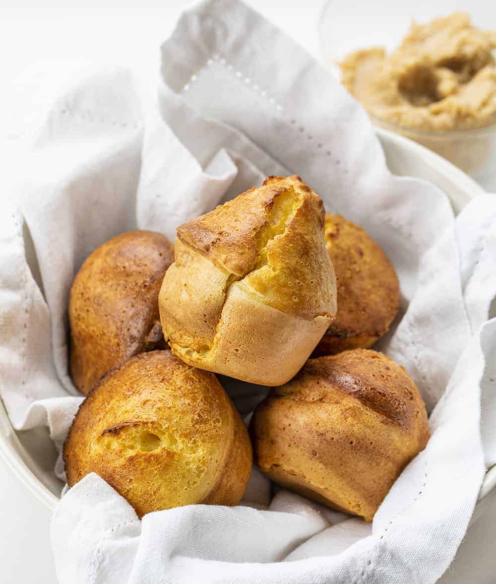 Basket of Sourdough Popovers on White Cloth with Cinnamon Butter