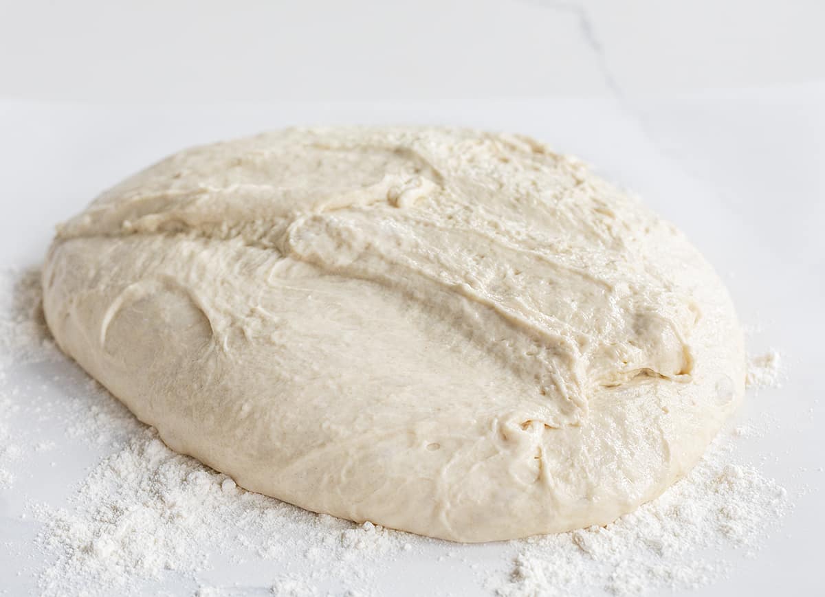 Sourdough bread that has risen and is on parchment with flour